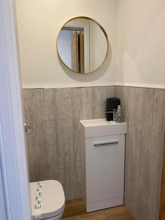 a bathroom with a white toilet and a mirror at The Nook Holiday Cottage in Aviemore