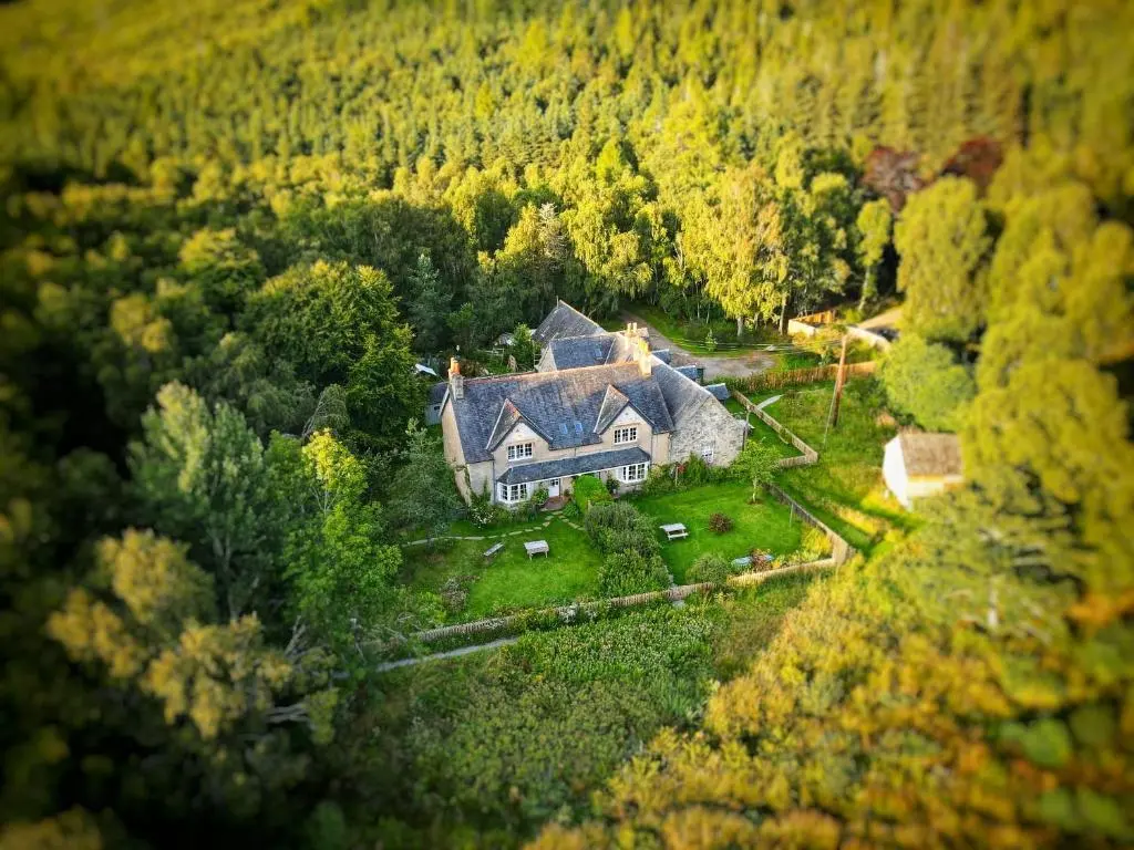 an aerial view of a large house in the forest at Rowan Cottage, CrannachCottages in Garve