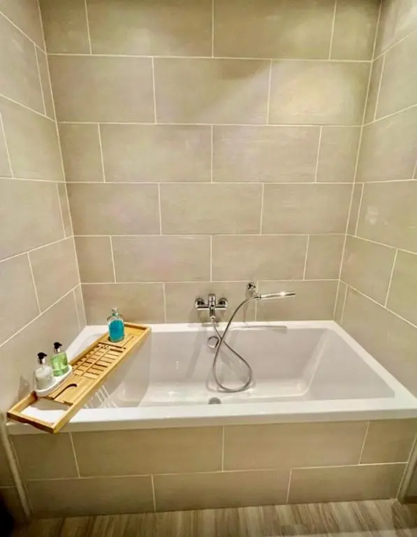 a bath tub with a shower in a bathroom at Stunning spacious Apartment on River Ness in Inverness