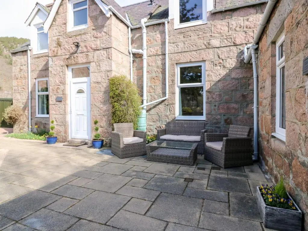 a patio in front of a stone house at Gairnlea House in Ballater