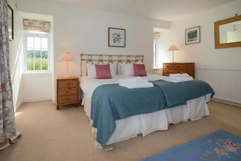 a bedroom with two beds and a window at Lower Bruntlands in Fochabers