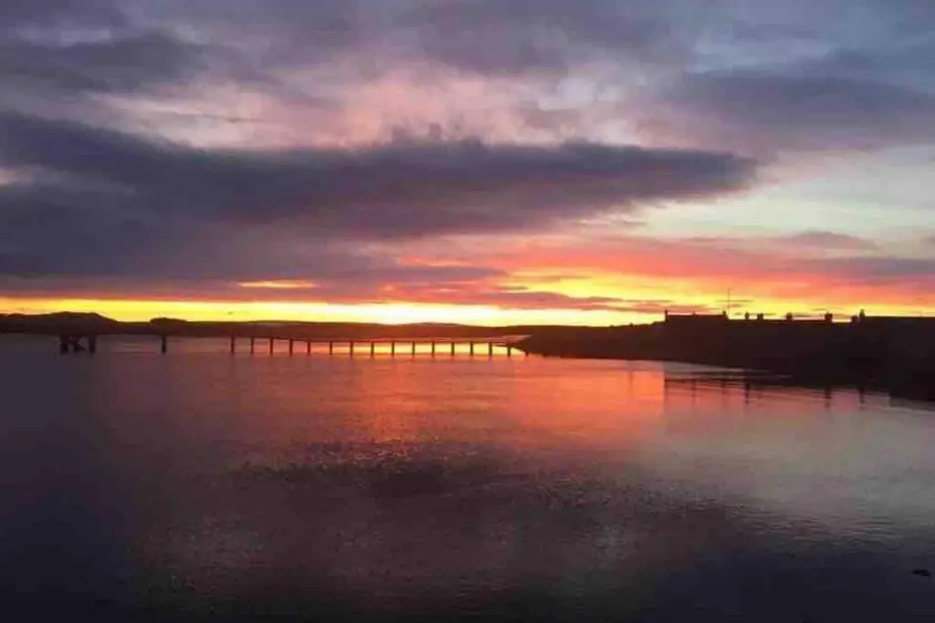 a sunset over a large body of water at Beachfront Lodge, Lossiemouth Bay in Lossiemouth