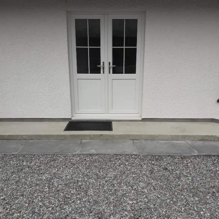 a white door on a white building with a stoop at Loch Ness House Blairbeg in Drumnadrochit