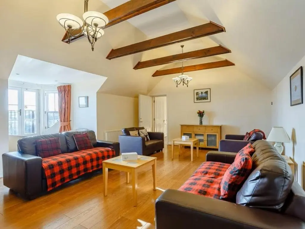 a living room with two couches and a table at Craiglea Lodge & Barn in Latheron