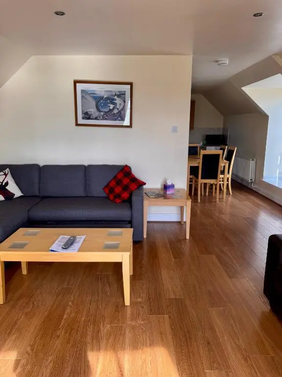 a living room with a blue couch and a table at Craiglea Lodge & Barn in Latheron