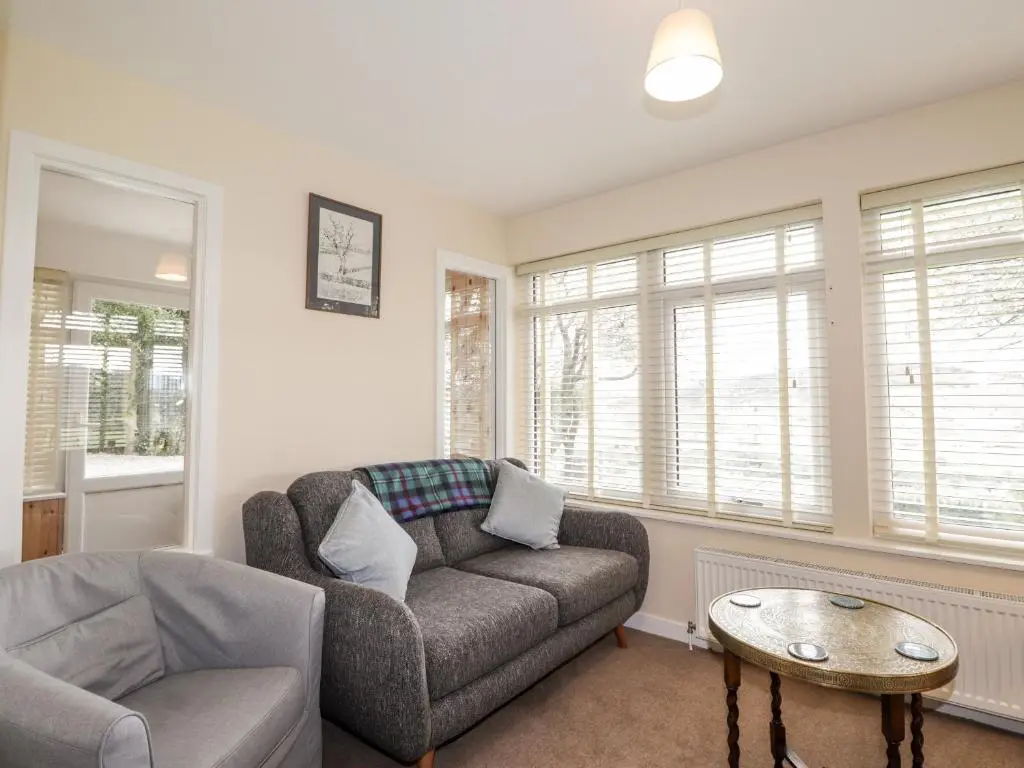a living room with a couch and a table at Balnaird Farmhouse in Strathpeffer