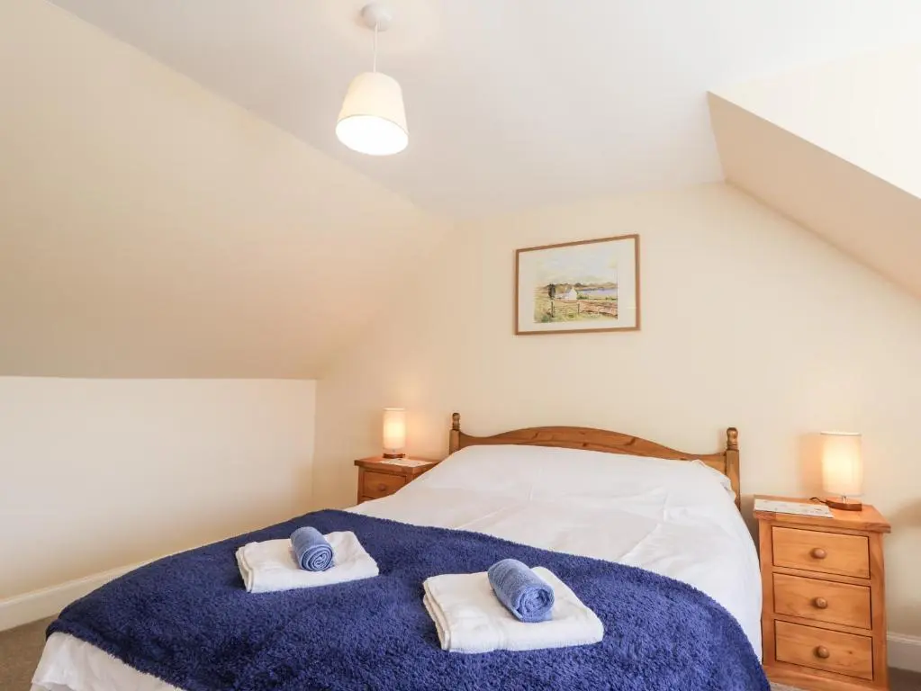 a bedroom with a bed with towels on it at Balnaird Farmhouse in Strathpeffer