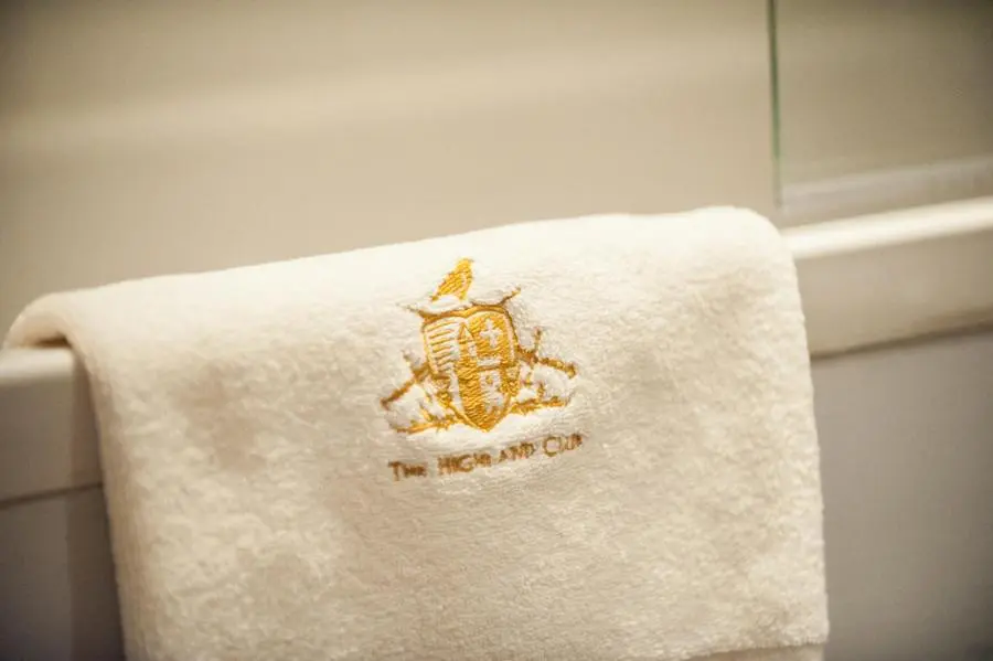 a towel with the hogan on it sitting on a toilet at Glenwood Apartment at The Highland Club in Fort Augustus