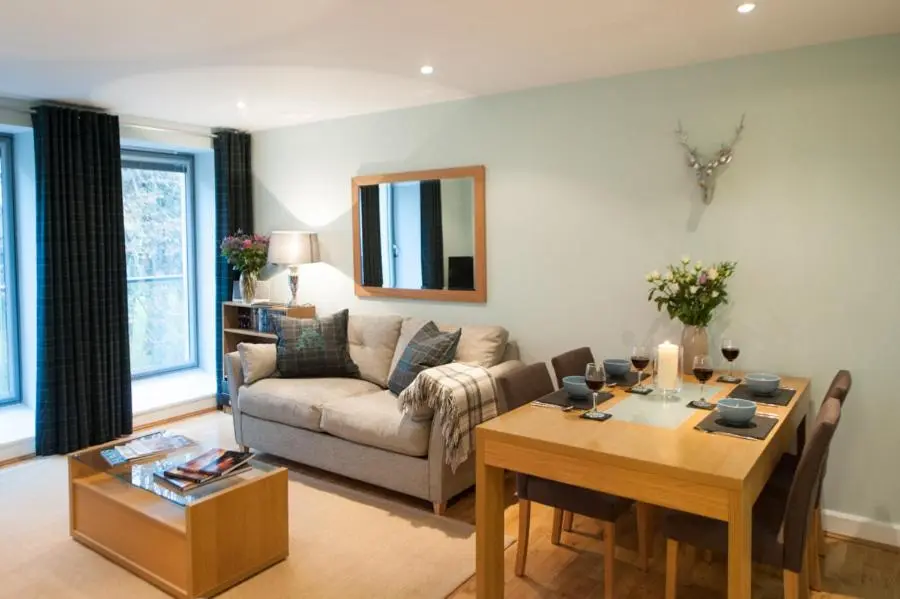 a living room with a table and a couch at Glenwood Apartment at The Highland Club in Fort Augustus