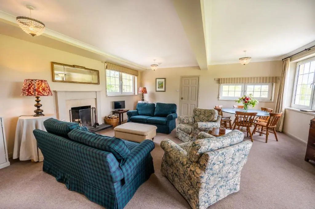 a living room with blue couches and a table at Braemoray in Evanton