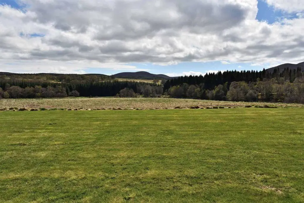a large green field with trees in the background at Strone in Boath