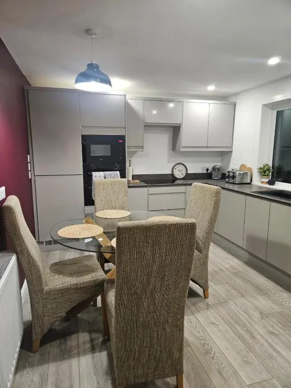 a kitchen with a table and chairs in a kitchen at No 14, 3 BED all with SMART TV's, Fully Fitted Kitchen, Ample PARKING, Ideal for TRADES, BUSINESS wanting comfort and a quality service REDUCTIONS FOR LONGER STAYS Langley Cottages and Apartments, in Wick