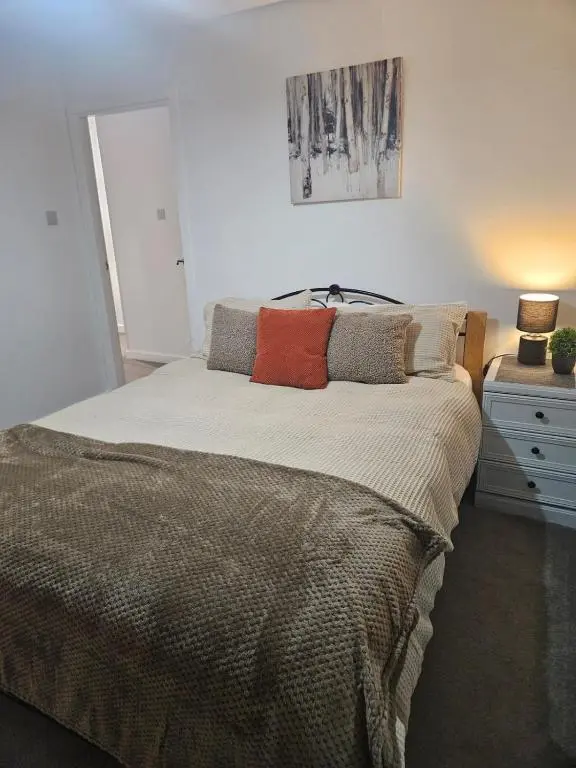 a bedroom with a large bed with pillows on it at No 14, 3 BED all with SMART TV's, Fully Fitted Kitchen, Ample PARKING, Ideal for TRADES, BUSINESS wanting comfort and a quality service REDUCTIONS FOR LONGER STAYS Langley Cottages and Apartments, in Wick