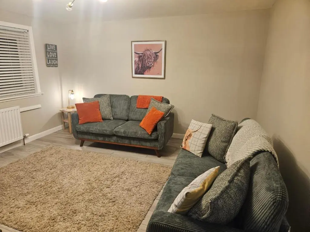 a living room with a couch and a chair at No 14, 3 BED all with SMART TV's, Fully Fitted Kitchen, Ample PARKING, Ideal for TRADES, BUSINESS wanting comfort and a quality service REDUCTIONS FOR LONGER STAYS Langley Cottages and Apartments, in Wick