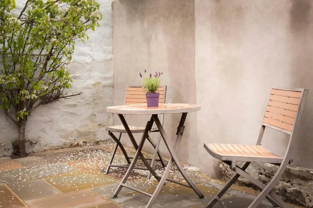 a table with two chairs and a potted plant on it at Pear Tree Cottage in Cullen