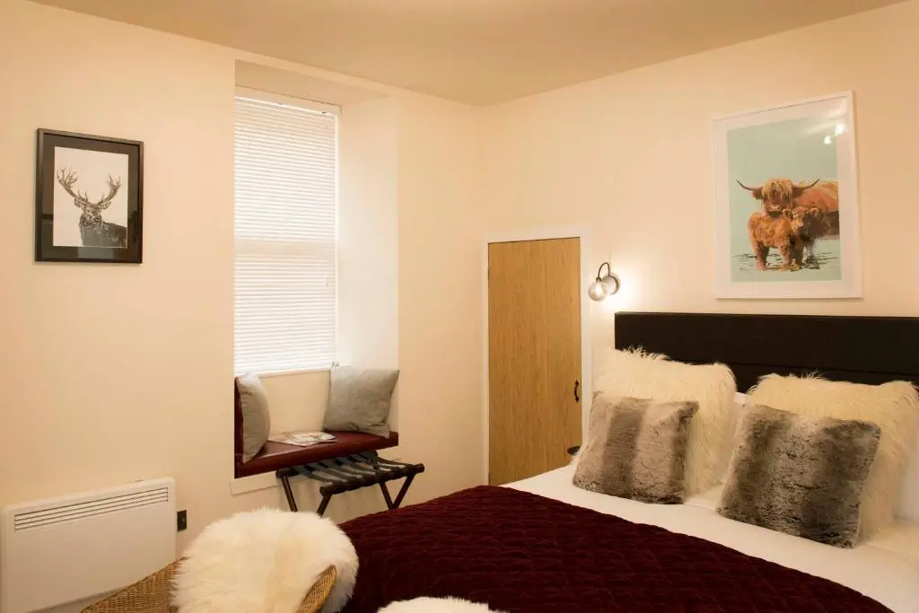 a bedroom with a large bed and a window at Pear Tree Cottage in Cullen