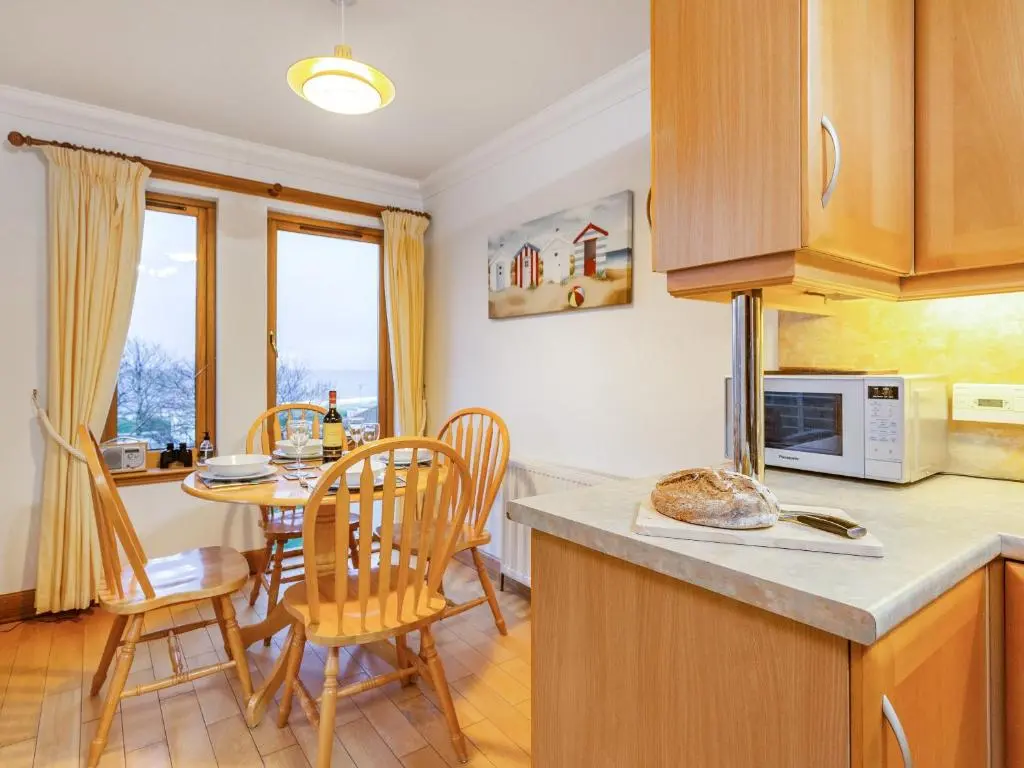 a kitchen and dining room with a table and chairs at Moray Firth View in Nairn