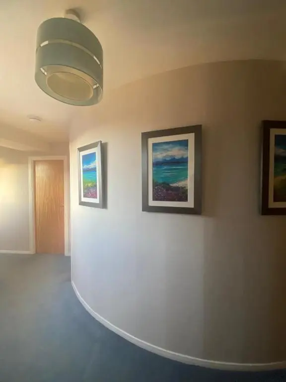 a room with three paintings on a wall with a light at Harbour and River View, Beach 50m from doorstep & free parking in Nairn