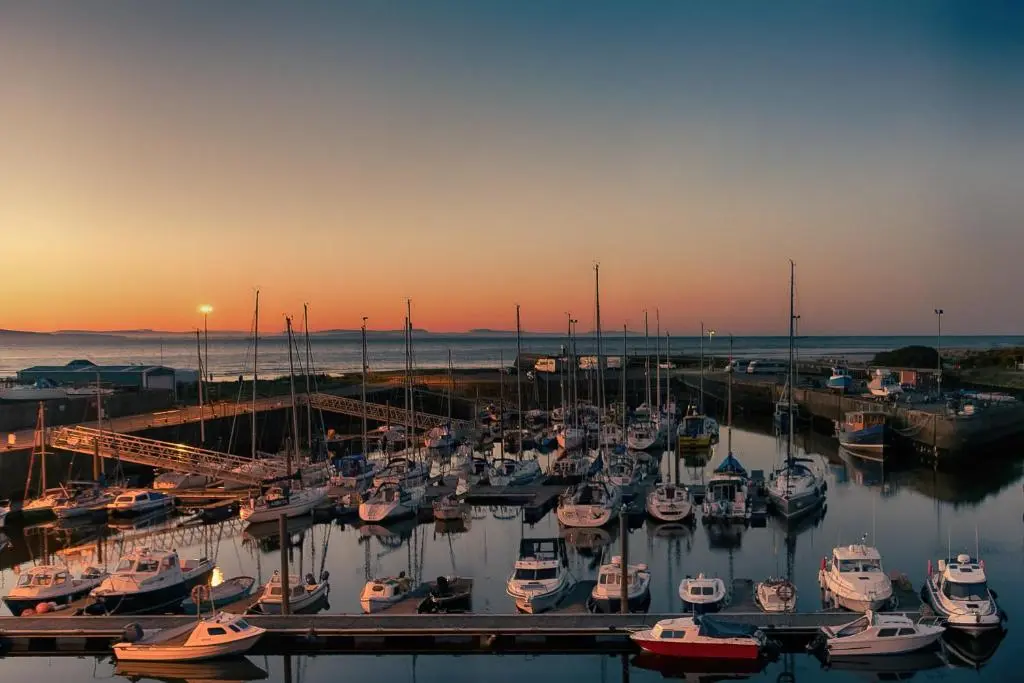 a group of boats docked in a marina at sunset at Harbour and River View, Beach 50m from doorstep & free parking in Nairn