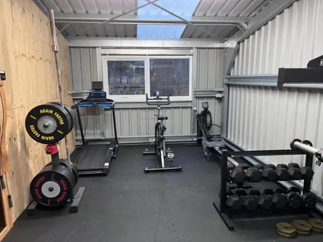 a garage with a gym with a bike and weights at Highland Holiday Cottages in Newtonmore