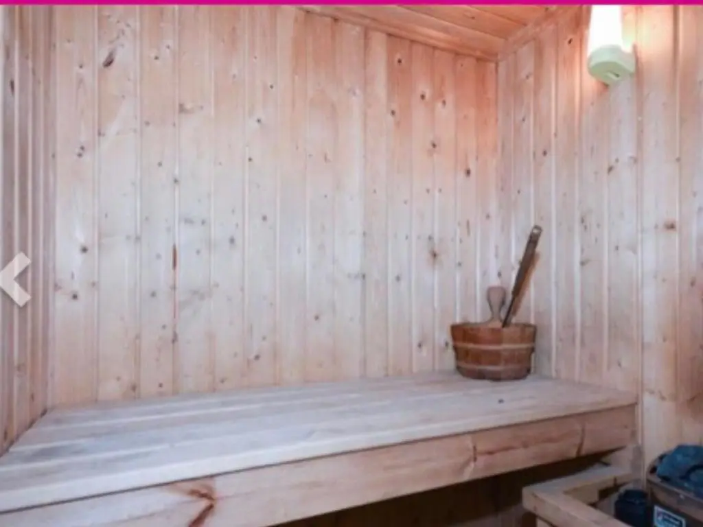a wooden bench in a sauna with a plant at Ben Rinnes Lodge Glenlivet Highlands in Auchnastank