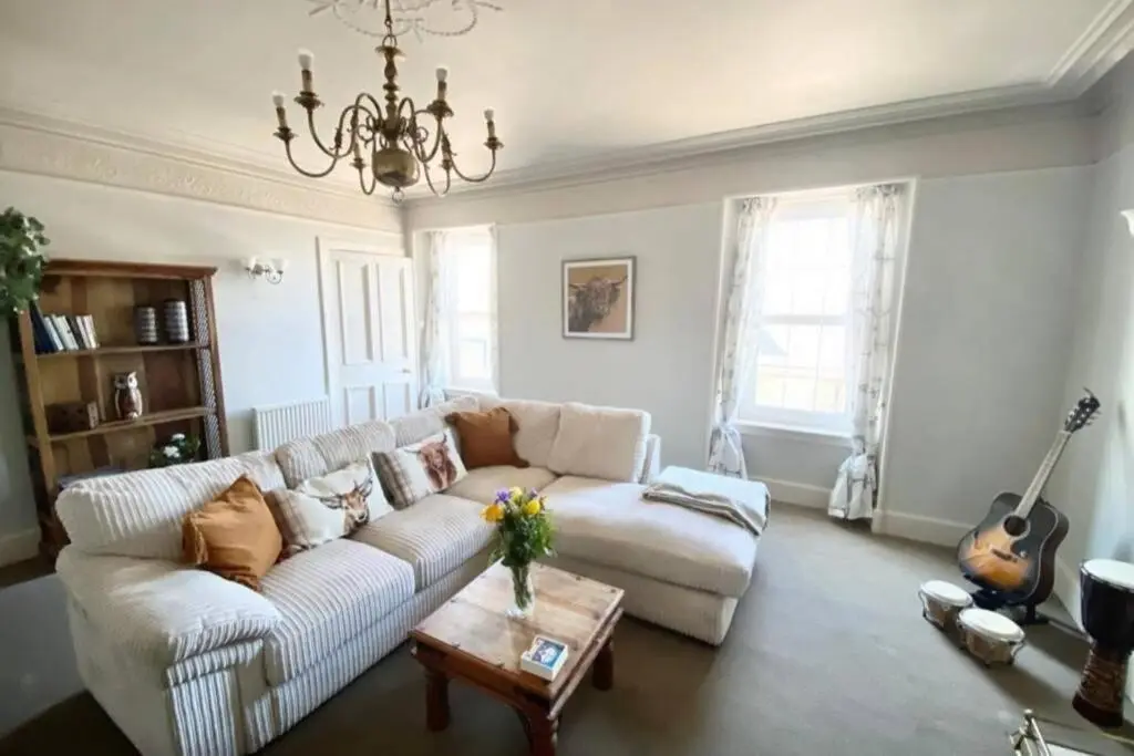 a living room with a white couch and a table at Chemist's House in Cullen