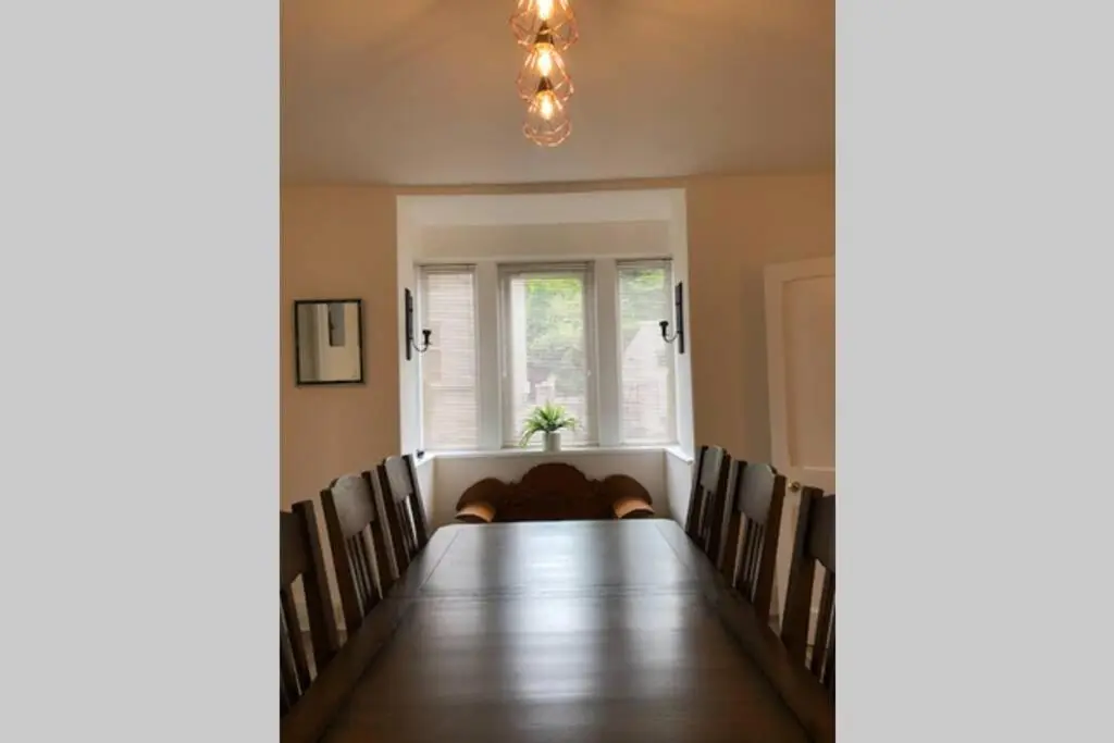 a dining room with a long table and chairs at Seacot Cottage in the heart of the Highlands in South Kessock