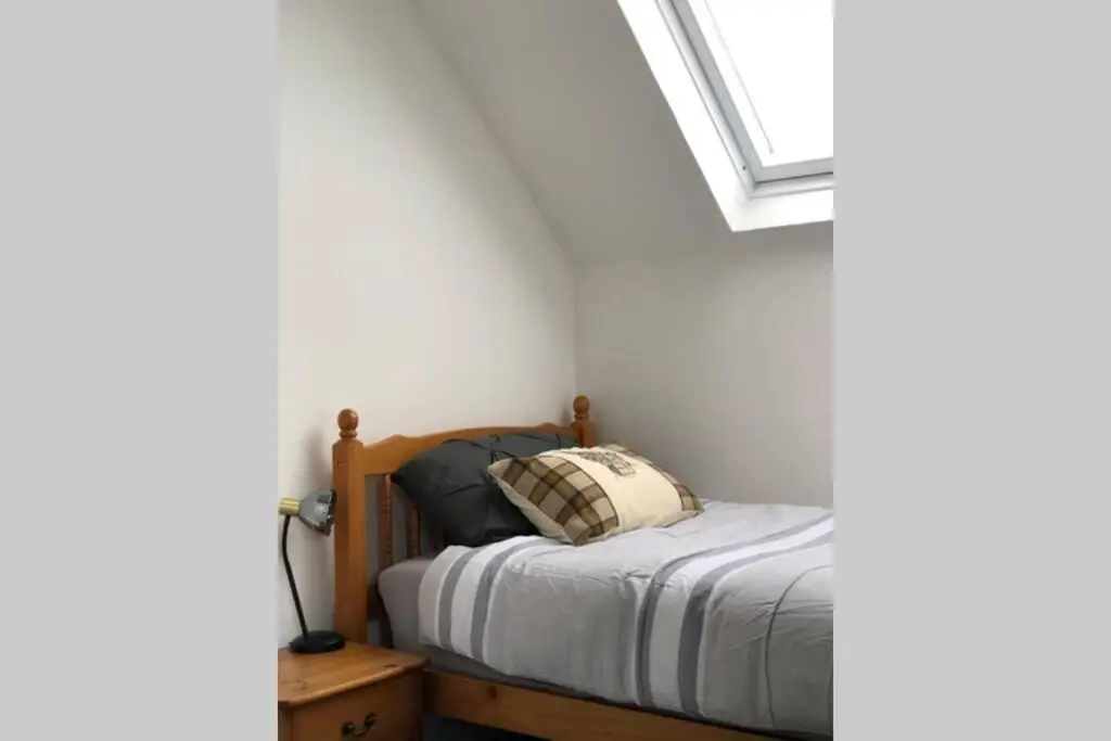 a bedroom with a bed and a window at Seacot Cottage in the heart of the Highlands in South Kessock