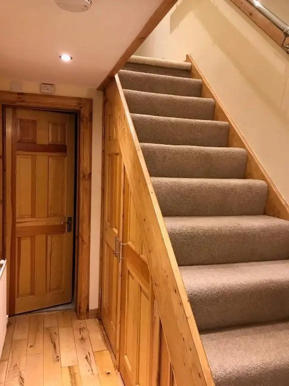 a staircase in a house with a wooden door at No 10 The Cottage in Inverness