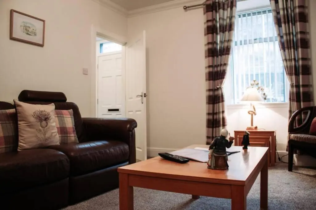 a living room with a couch and a coffee table at Craigewan Cottage Seatown Cullen in Cullen