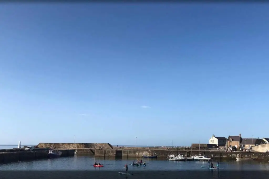 a group of boats in the water near a harbor at Craigewan Cottage Seatown Cullen in Cullen