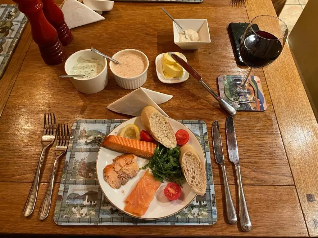 a table with a plate of food on a table at Foresters Lodge bed and breakfast, near loch ness in Inverfarigaig