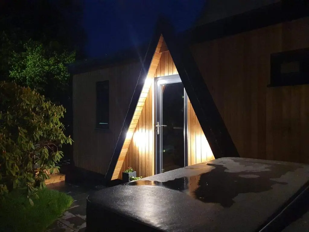 a house with a window at night with a light at Little Woodbine in Tain
