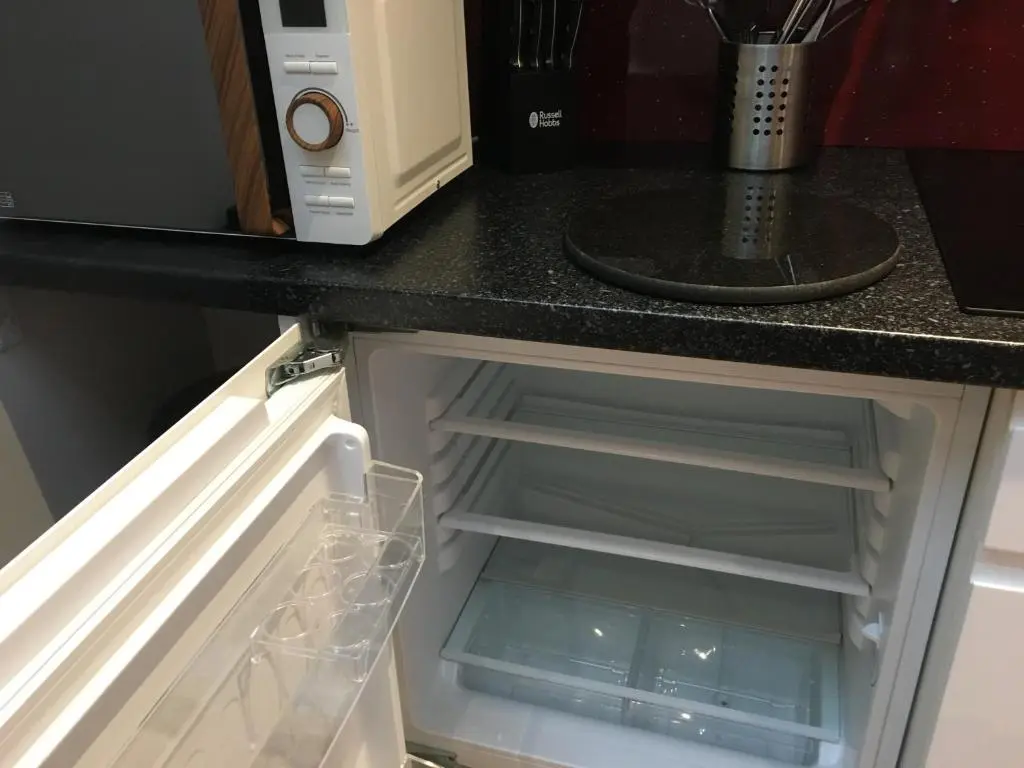 an open refrigerator in a kitchen with a microwave at Modern 1 Bedroom Apartment central Inverness city in Inverness