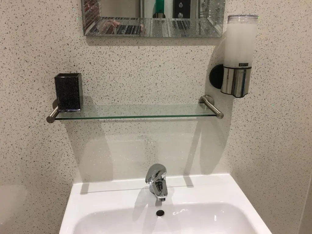 a bathroom sink with a glass shelf above it at Modern 1 Bedroom Apartment central Inverness city in Inverness