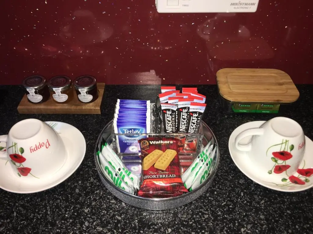 a table with a basket of candy and two cups at Modern 1 Bedroom Apartment central Inverness city in Inverness