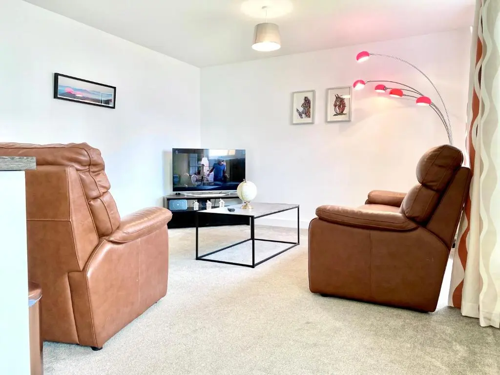 a living room with two chairs and a tv at Serviced Accommodation Moray Cawdor Avenue, Elgin in Elgin