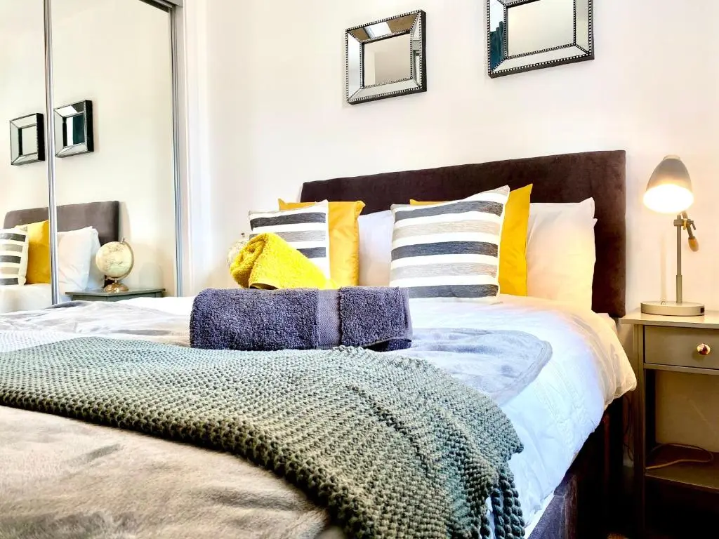 a bedroom with a bed with yellow and white pillows at Serviced Accommodation Moray Cawdor Avenue, Elgin in Elgin