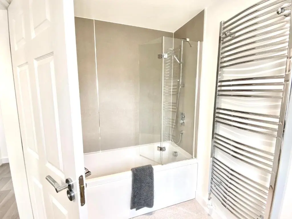 a bathroom with a tub and a shower with a mirror at Serviced Accommodation Moray Cawdor Avenue, Elgin in Elgin