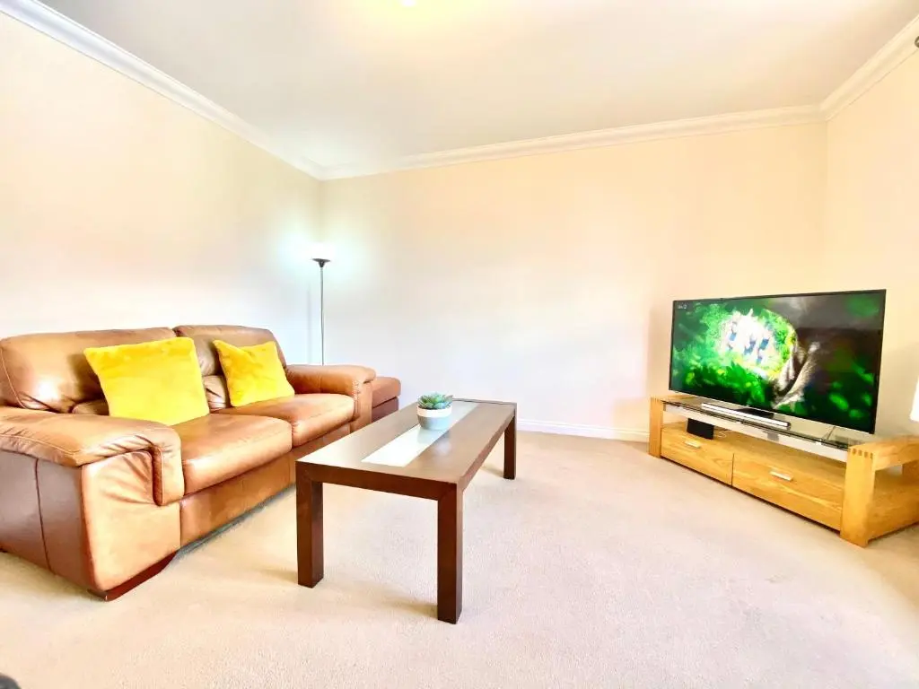 a living room with a couch and a flat screen tv at 100 Thornhill Drive, Elgin in Elgin