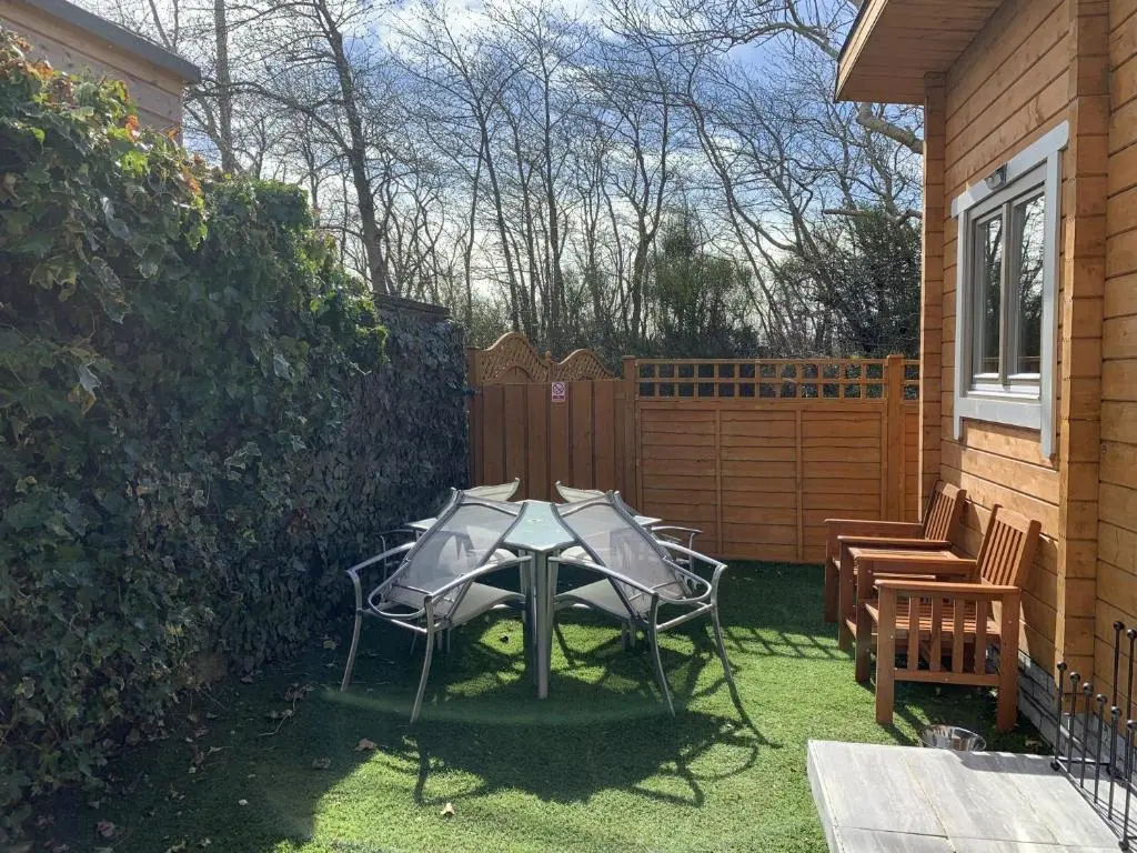 a patio with a table and chairs in a yard at Immaculate Cabin 5 mins to Inverness Dog friendly in Inverness