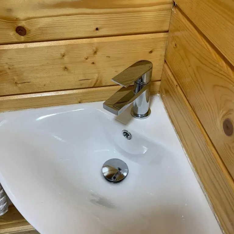 a white sink in a bathroom with a wooden cabinet at Immaculate Cabin 5 mins to Inverness Dog friendly in Inverness