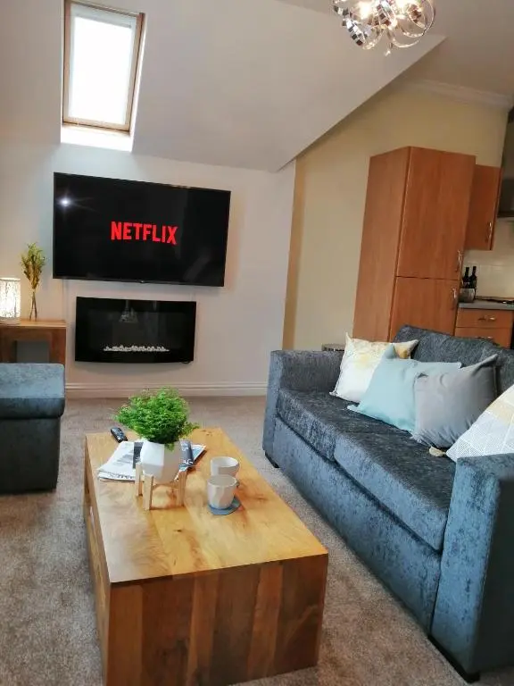 a living room with a couch and a coffee table at Seaforth House Apartment in Elgin