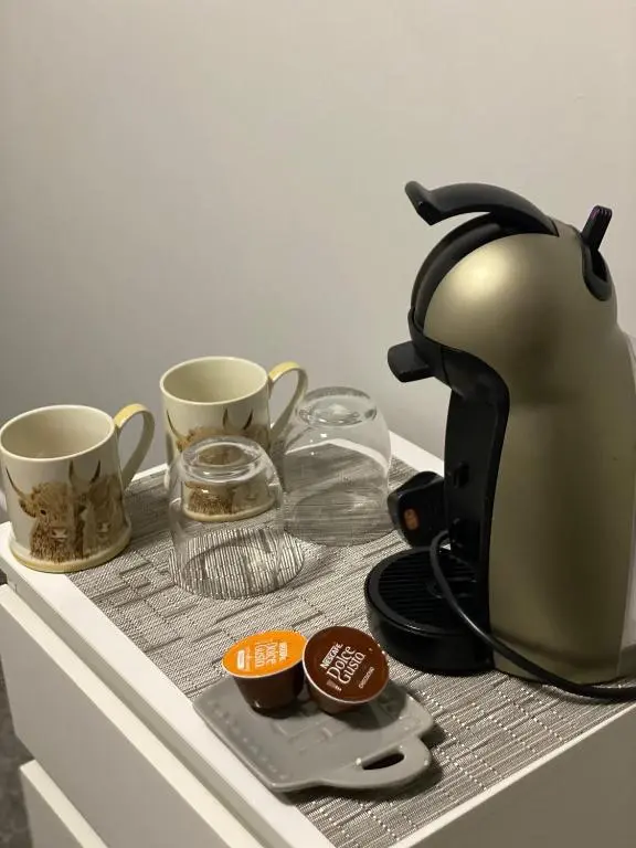 a tea kettle sitting on a counter with two cups at Shore Street Apartments in Inverness