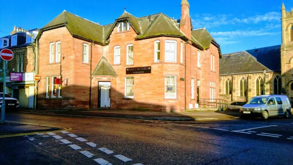 an old brick building with a car parked in front of it at Flat 1 Castlebank house Flats in Dingwall