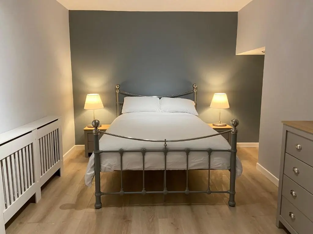 a bedroom with a bed with two lamps on two tables at Islas Cottage, a home in the Heart of Speyside in Dufftown
