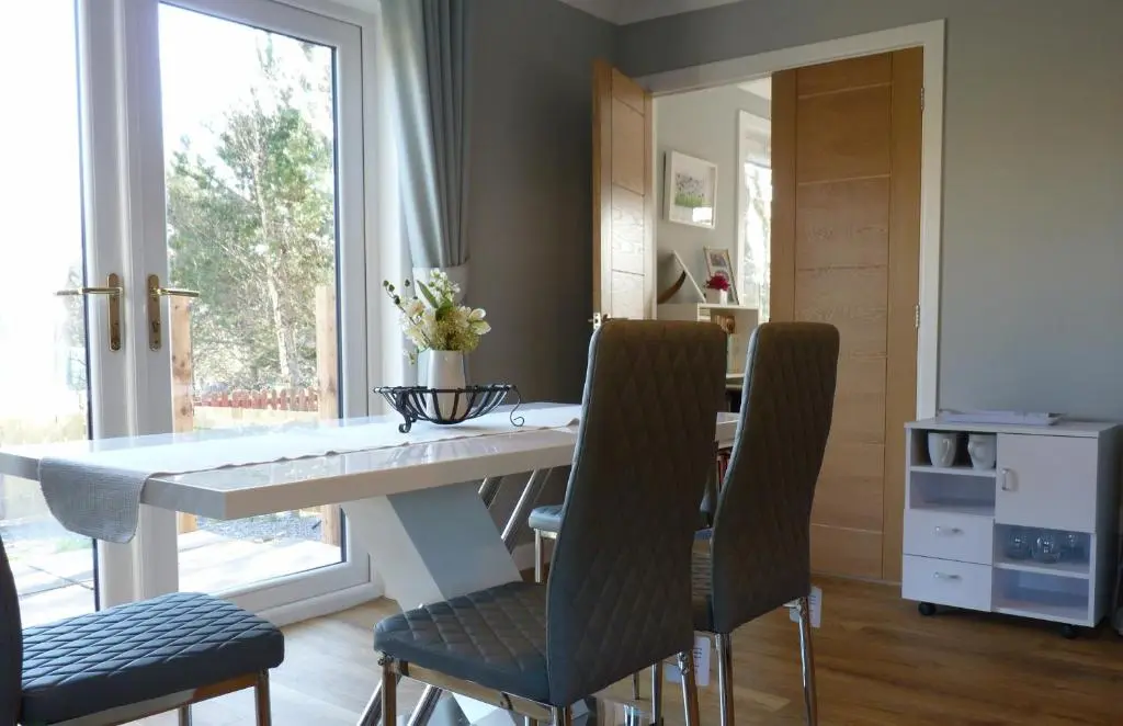 a dining room with a white table and chairs at Tanleys B&B in Grantown on Spey