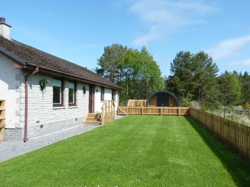 a large yard with a fence and a house at Tanleys B&B in Grantown on Spey