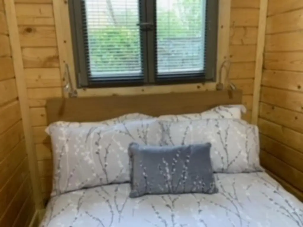 a bedroom with a bed with a blue pillow on it at Immaculate cabin 5 mins to Inverness dogs welcome in Inverness