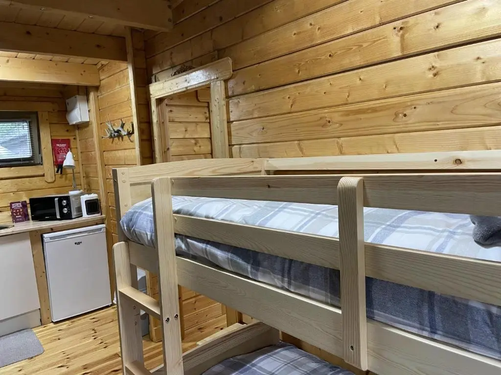 a bedroom with two bunk beds in a log cabin at Immaculate cabin 5 mins to Inverness dogs welcome in Inverness